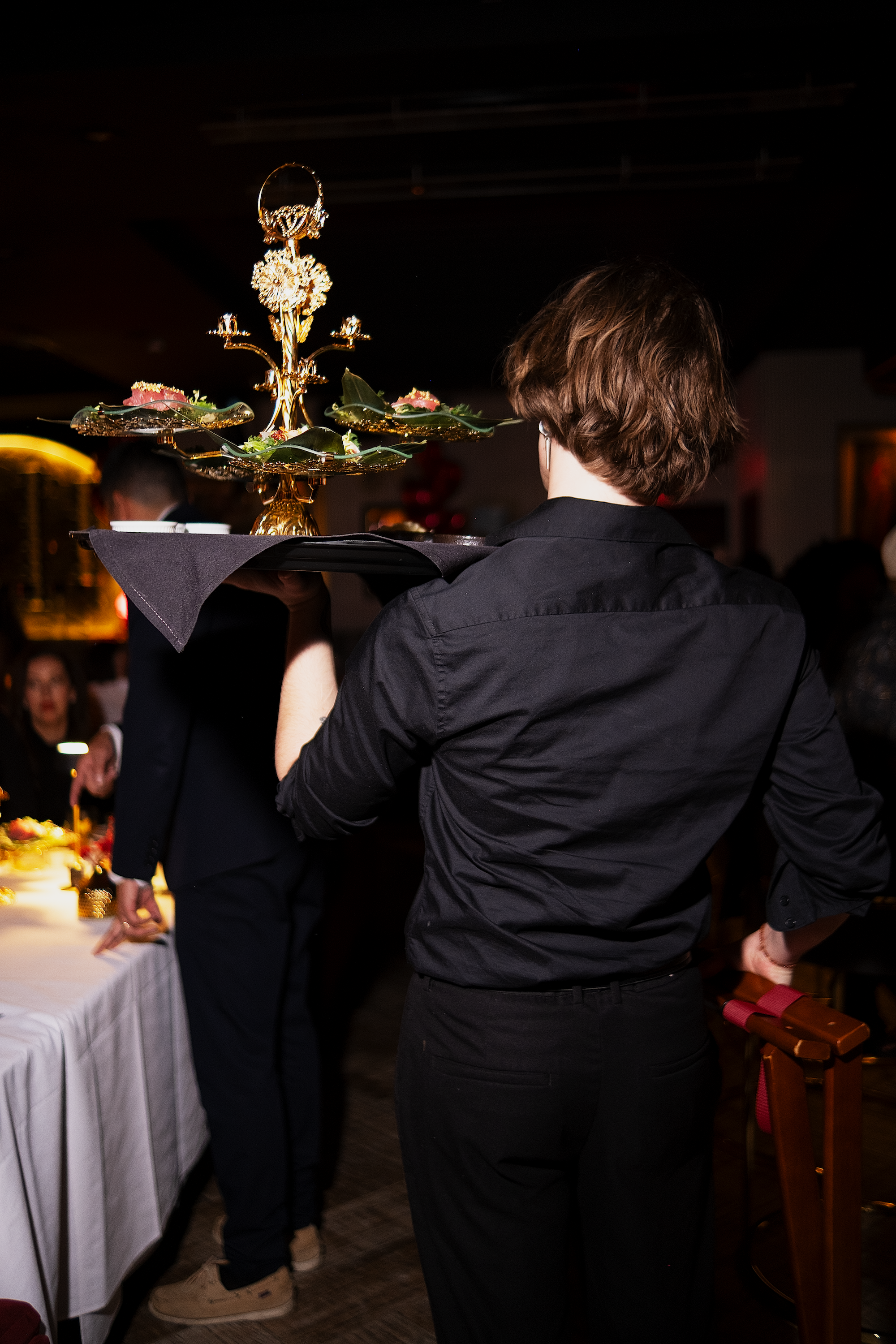 Waiter bringing a seafood platter, including oysters, Bigeye Tuna, and Wild Maine Lobster, at ADKT, the best French-Japanese fusion restaurant in LA